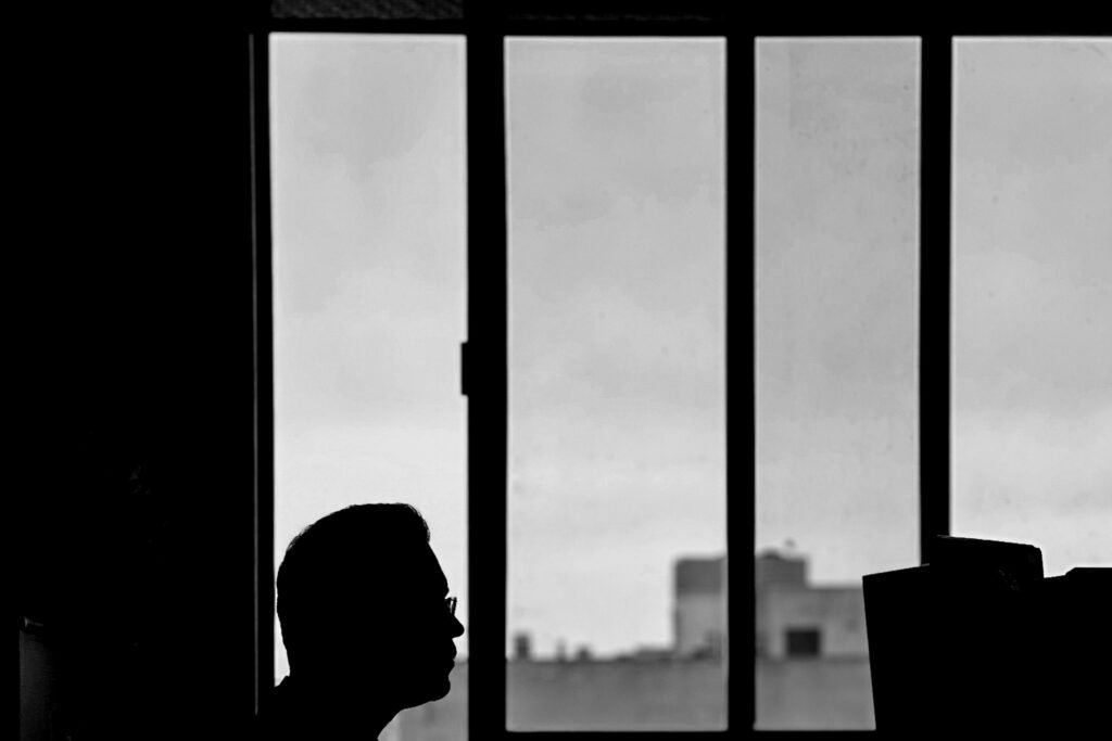 Silhouette of a person working at a window desk