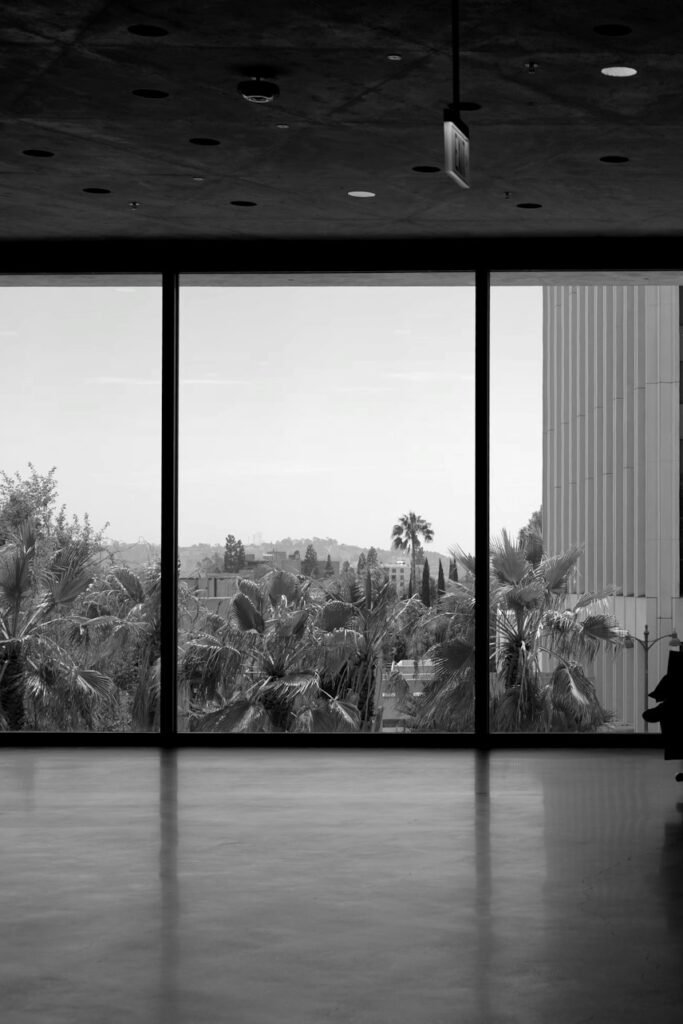 A person in silhouette before large windows