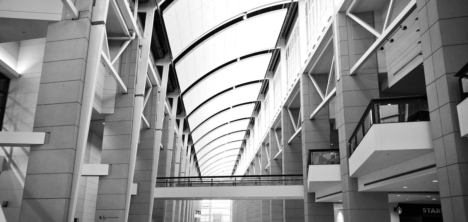 People walking through a modern glass atrium